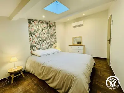 a bedroom with a large bed and a window at Gite de l'avenue in Sigean
