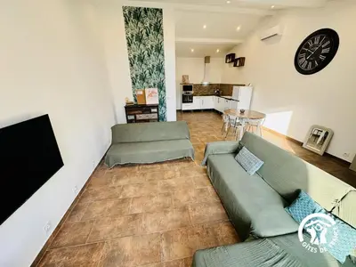 a living room with a couch and a table at Gite de l'avenue in Sigean