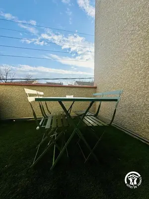 a glass table sitting on the side of a building at Gite de l'avenue in Sigean