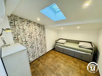 a small bedroom with a bed and a window at Gite de l'avenue in Sigean