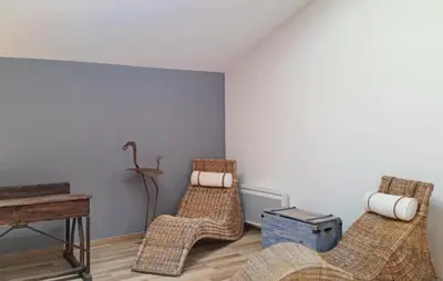 a room with three wicker chairs and a table at Nice Home In Narbonne With Sauna in Narbonne