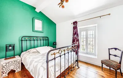 a bedroom with a bed and a green wall at Awesome Home In Capendu in Capendu