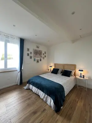 a bedroom with a bed and a large window at Charmante ferme familiale in Guitalens