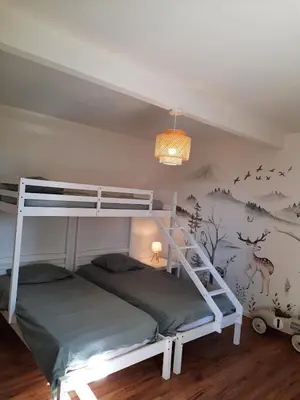 a bedroom with a bunk bed and a mural of deer at Charmante ferme familiale in Guitalens