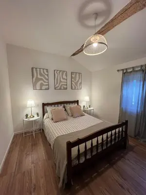 a bedroom with a large bed and two night stands at Charmante ferme familiale in Guitalens