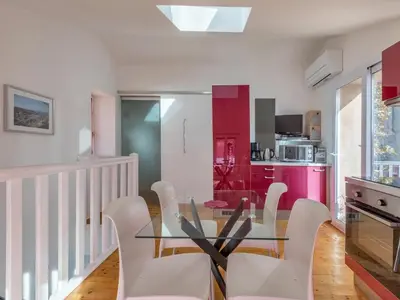 a dining room with a glass table and white chairs at Opuntia Teouliero location en Méditerranée in Escales