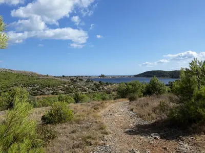 a dirt road with a view of a lake at Opuntia Teouliero location en Méditerranée in Escales