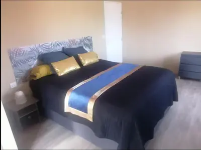 a bedroom with a large bed with blue and gold pillows at Suite parentale avec terrasse solarium in Saint-André-de-Roquelongue