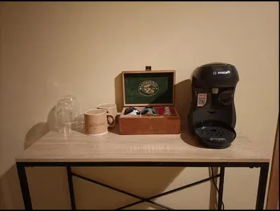 a coffee maker and a box on a table with cups at Suite parentale avec terrasse solarium in Saint-André-de-Roquelongue