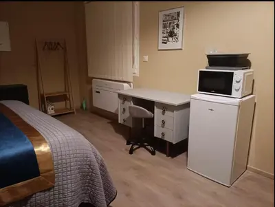 a bedroom with a bed and a desk with a microwave at Suite parentale avec terrasse solarium in Saint-André-de-Roquelongue