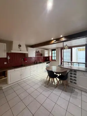 a bedroom with wooden cabinets and a bed and windows at Maison de village avec spa privé & grande terrasse calme & détente in Dourgne