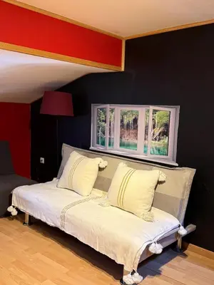 a bed in a room with two windows at Maison de village avec spa privé & grande terrasse calme & détente in Dourgne