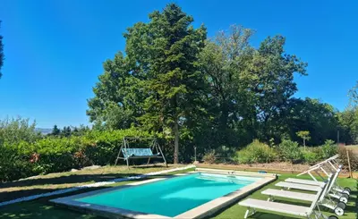 a swimming pool in a yard with a swing at Aux couleurs de la terre d'oc in Villepinte