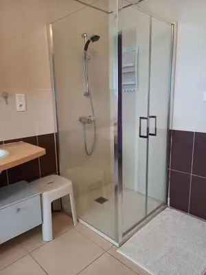 a shower with a glass door in a bathroom at Aux couleurs de la terre d'oc in Villepinte
