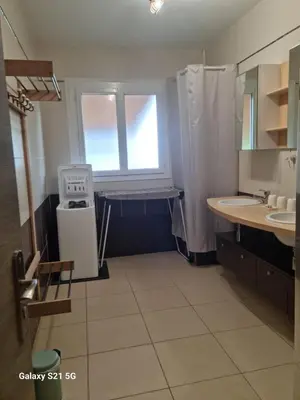 a bathroom with two sinks and a shower and a window at Aux couleurs de la terre d'oc in Villepinte