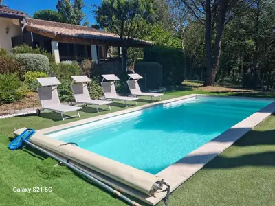 a swimming pool with lounge chairs and a swimming pool at Aux couleurs de la terre d'oc in Villepinte