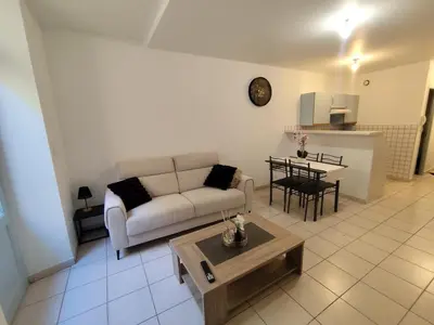 a living room with a couch and a table at Escale au pied de la cité in Carcassonne