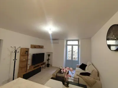 a living room with a couch and a tv at Escale au pied de la cité in Carcassonne