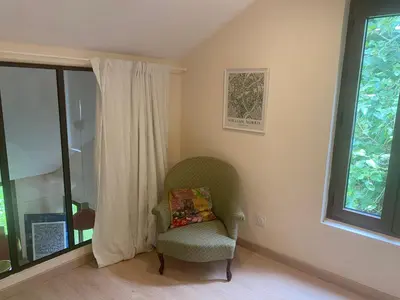 a living room with a chair and a window at Chambres d'hôtes -L'Atelier du Presbytère