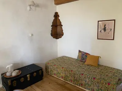 a small bedroom with a bed and a table at Chambres d'hôtes -L'Atelier du Presbytère