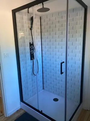 a walk in shower with a glass enclosure at Chambres d'hôtes -L'Atelier du Presbytère