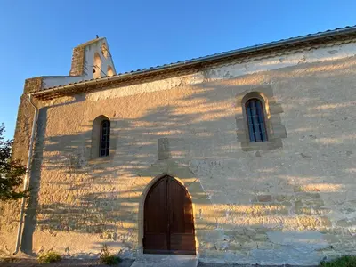 an old church with a wooden door and a tower at Chambres d'hôtes -L'Atelier du Presbytère