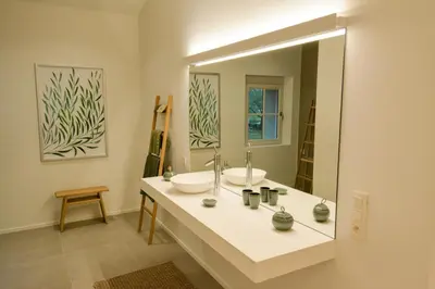 a bathroom with a sink and a large mirror at Le domaine de rigou in Lasbordes