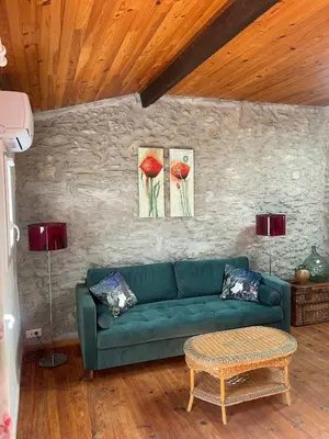 a living room with a green couch and two paintings at Maison Au Phil de Lau in Raissac-dʼAude