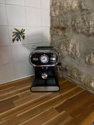 a coffee maker sitting on a wooden floor at Maison Au Phil de Lau in Raissac-dʼAude