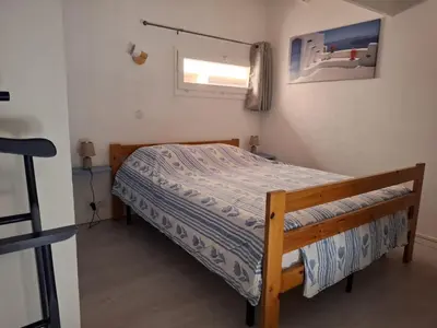 a bedroom with a bed in a room with a window at Appartement T2 entre mer et lac in Port-la-Nouvelle