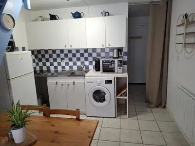 a kitchen with a washing machine and a microwave at Appartement T2 entre mer et lac in Port-la-Nouvelle