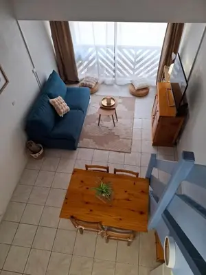 a living room with a blue couch and a table at Appartement T2 entre mer et lac in Port-la-Nouvelle