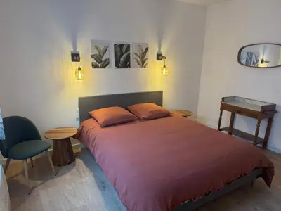 a bedroom with a bed and a table and a chair at Appartement centre ville Sigean in Sigean