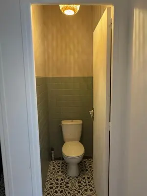 a bathroom with a white toilet in a room at Appartement centre ville Sigean in Sigean