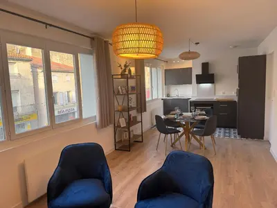 a living room with a table and chairs and a kitchen at Appartement centre ville Sigean in Sigean