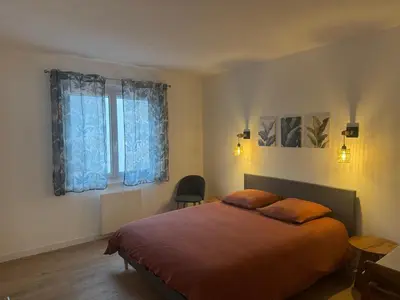 a bedroom with a bed and a table and a window at Appartement centre ville Sigean in Sigean