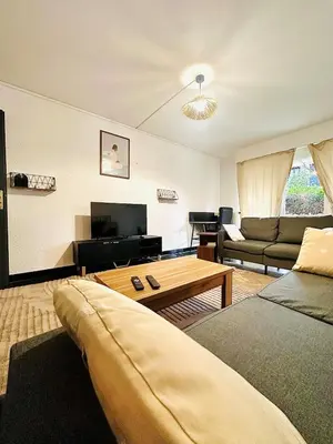 a living room with a couch and a coffee table at Les Fleurs de la Cité - T3 Parking privé et Terrasse Jardin Privé in Carcassonne