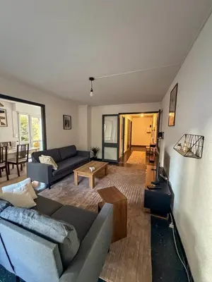 a living room with a couch and a coffee table at Les Fleurs de la Cité - T3 Parking privé et Terrasse Jardin Privé in Carcassonne