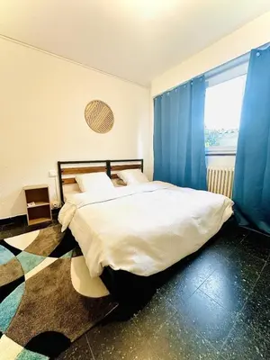 a bedroom with a large bed with blue curtains at Les Fleurs de la Cité - T3 Parking privé et Terrasse Jardin Privé in Carcassonne