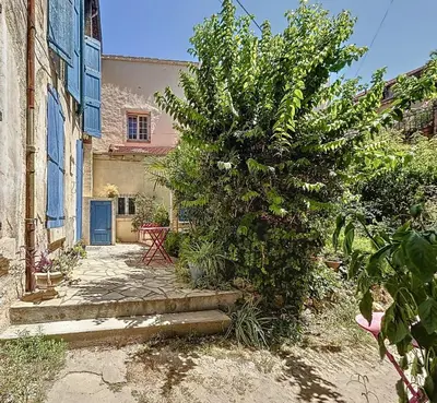 a large bush in front of a house with a building at Charmant T2 Narbonne centre in Narbonne