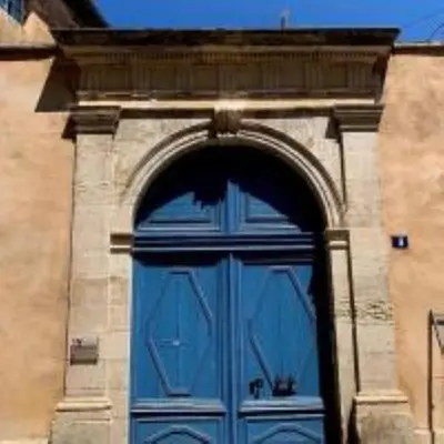 a large blue door on a building with an arch at Charmant T2 Narbonne centre in Narbonne