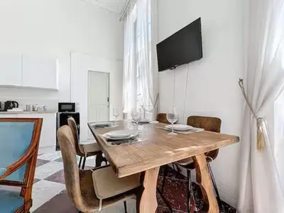 a dining room with a table with wine glasses on it at Charmant T2 Narbonne centre in Narbonne