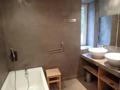 a bathroom with two sinks and a bath tub and a mirror at Beautiful 17th century character residence in Fontiers-Cabardès