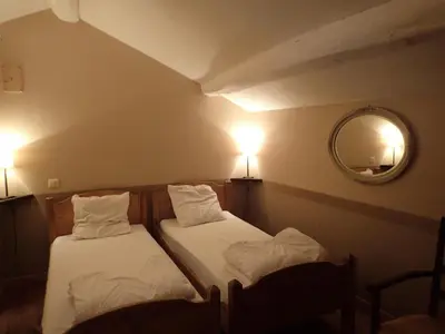 two beds in a room with a mirror and lights at Beautiful 17th century character residence in Fontiers-Cabardès