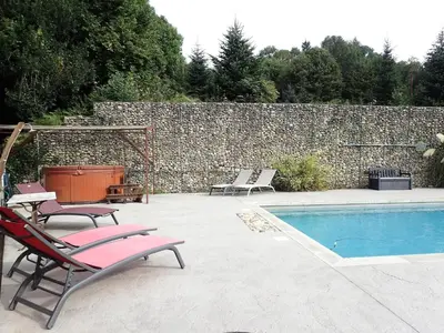 a pool with two lounge chairs next to a wall at Beautiful 17th century character residence in Fontiers-Cabardès