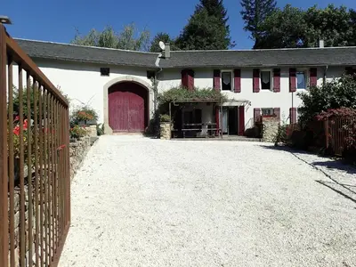 a white house with a red door and a driveway at Beautiful 17th century character residence in Fontiers-Cabardès