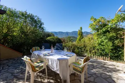 a table with wine glasses and chairs on a patio at La Petite Étoile - Maison 2 Chambres à Quillan in Quillan