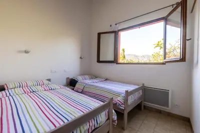two twin beds in a room with a window at La Petite Étoile - Maison 2 Chambres à Quillan in Quillan