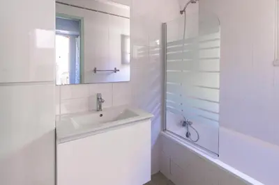 a white bathroom with a sink and a shower at La Petite Étoile - Maison 2 Chambres à Quillan in Quillan
