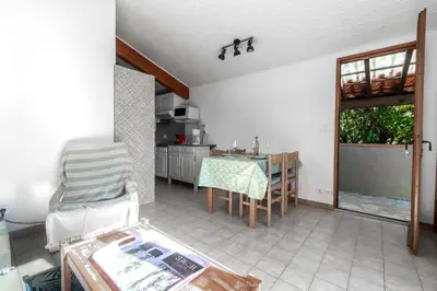 a living room with a table and a kitchen at La Petite Étoile - Maison 2 Chambres à Quillan in Quillan